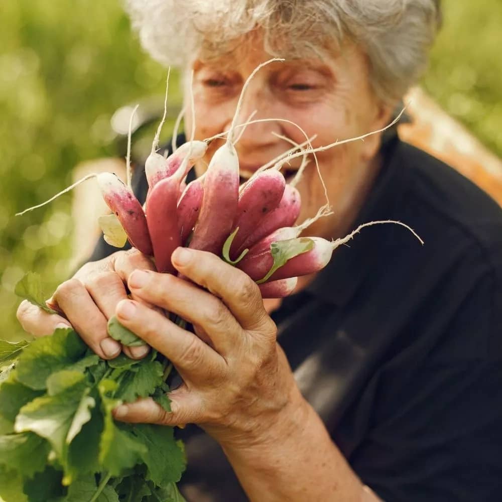 Old woman holding vegetables in hand